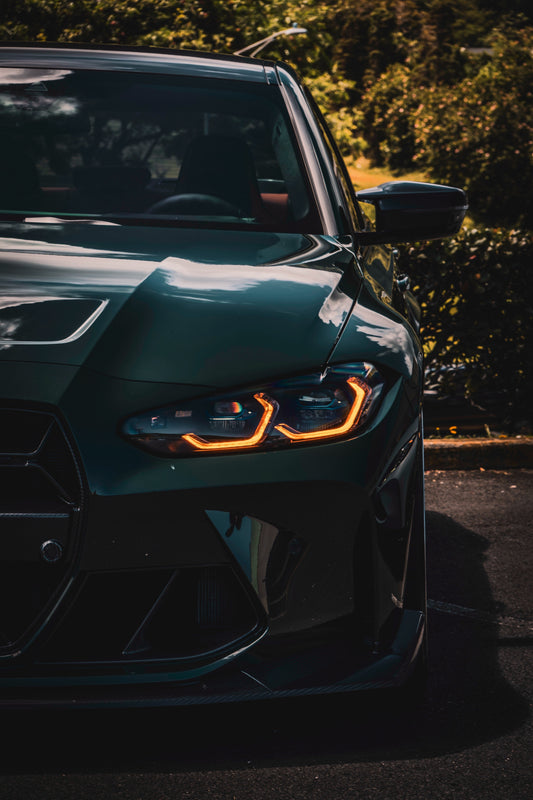 A close-up image of a car's front end featuring the CSL Style DRL LED Module Set with yellow lighting, enhancing the aggressive and sporty appearance of the vehicle.