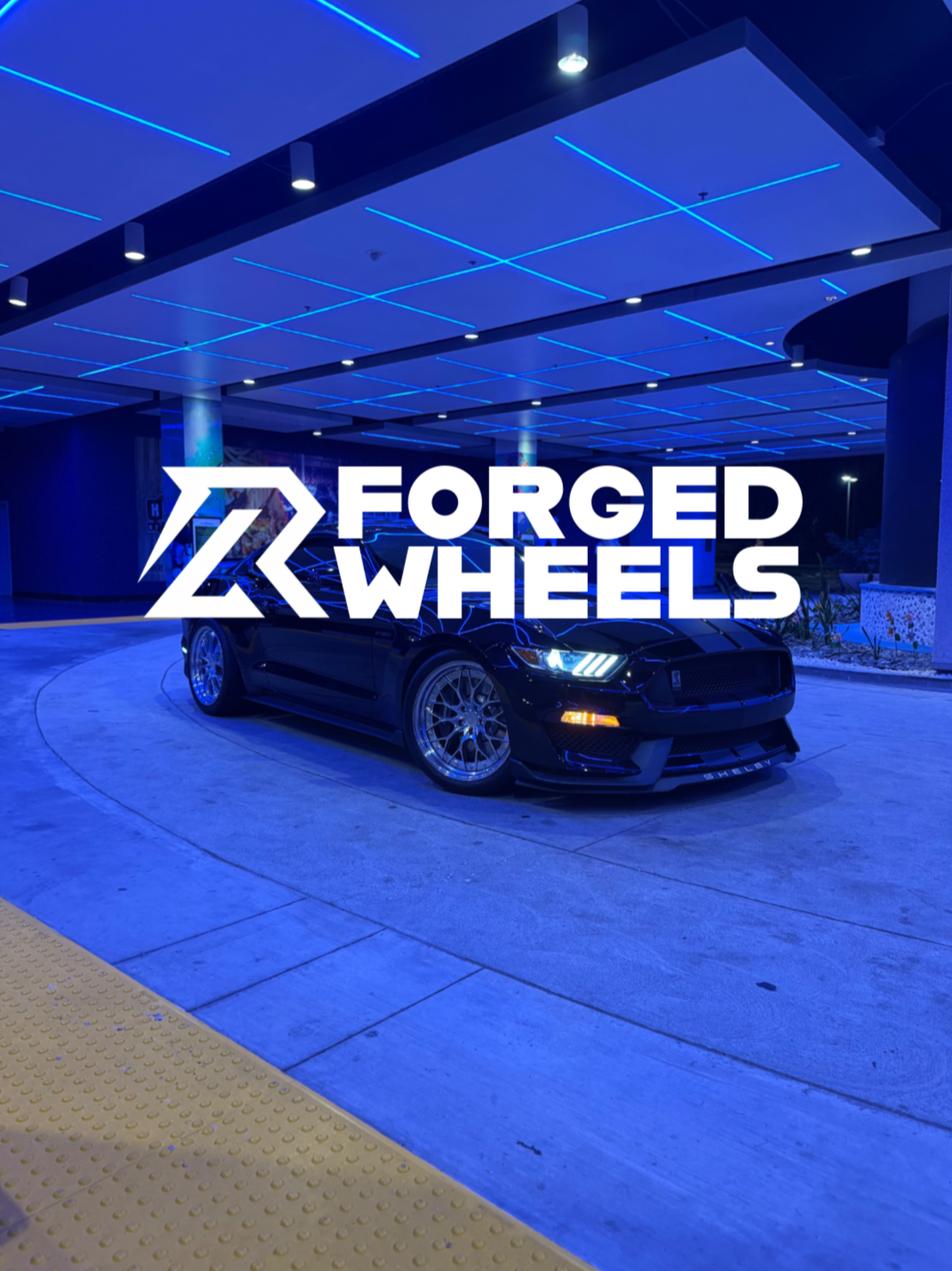Car on a track with 'Forged Wheels' logo in the foreground